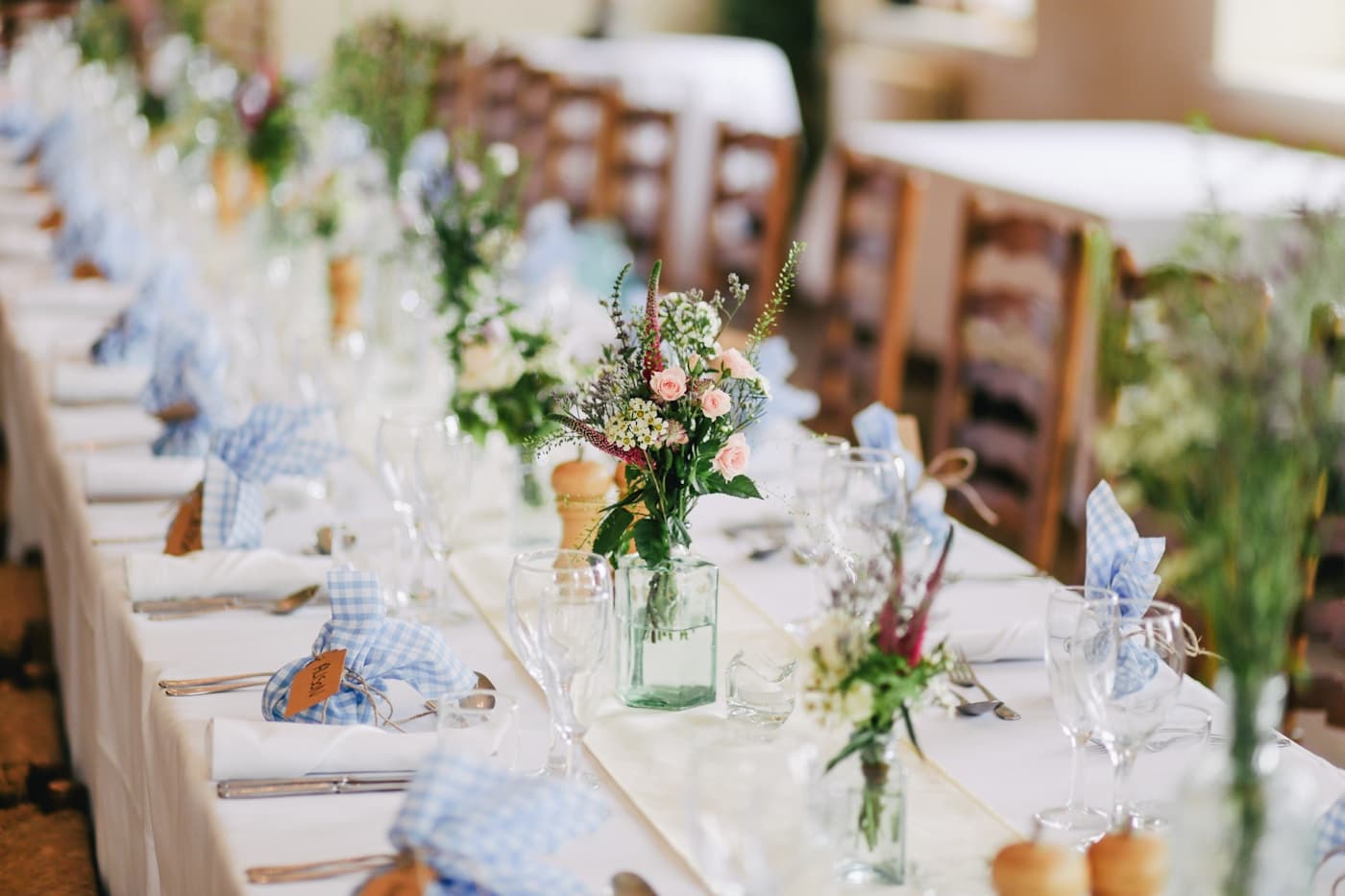 Table de mariage dressée avec fleurs, verres et détails de papeterie
